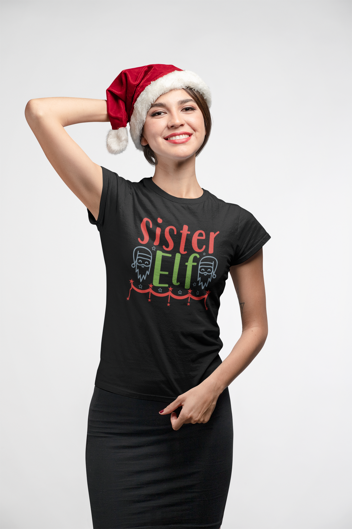 Woman in a Santa hat wearing the Sister Elf black t-shirt