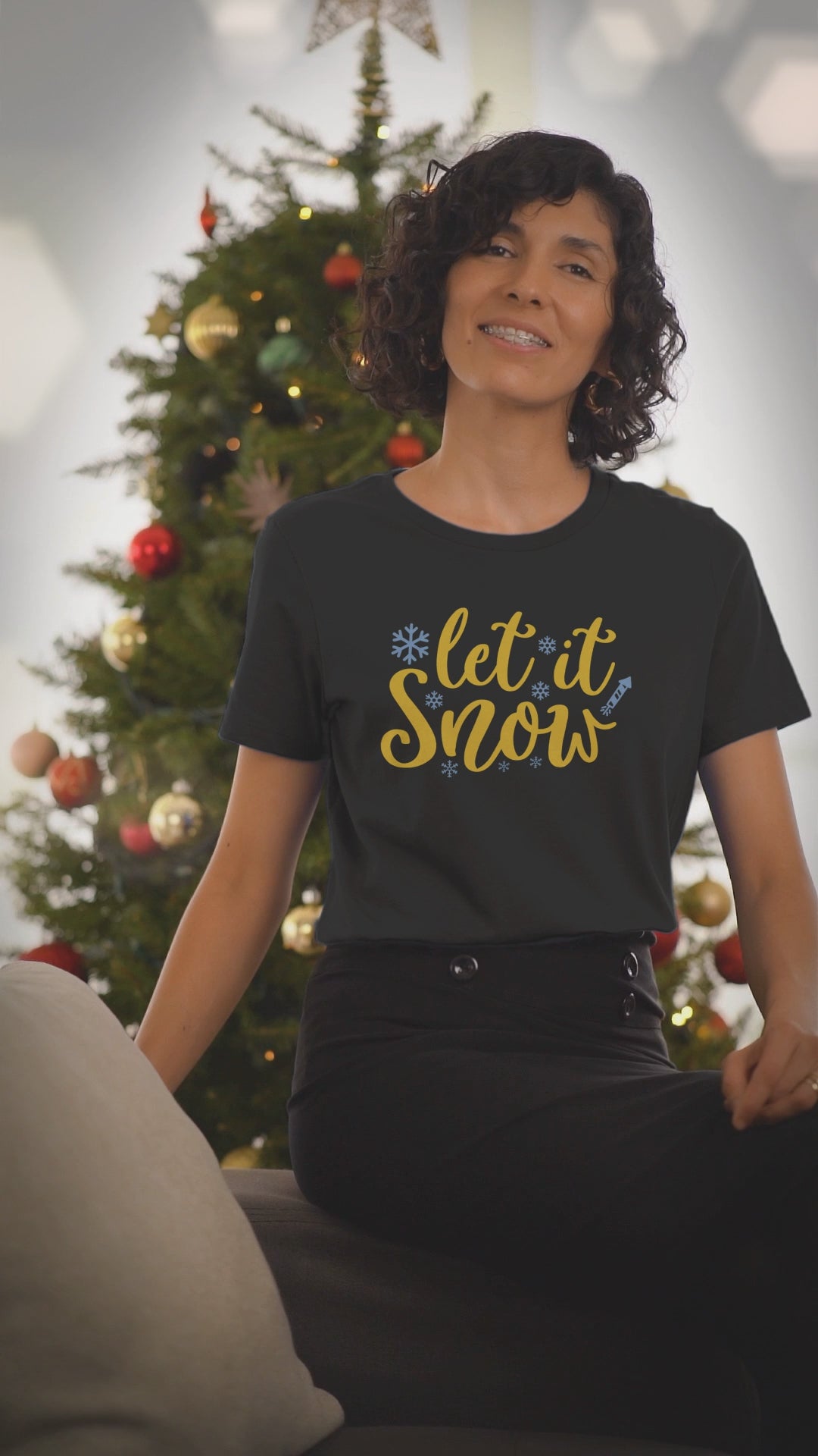 Video of a woman wearing the Let It Snow black Christmas t-shirt